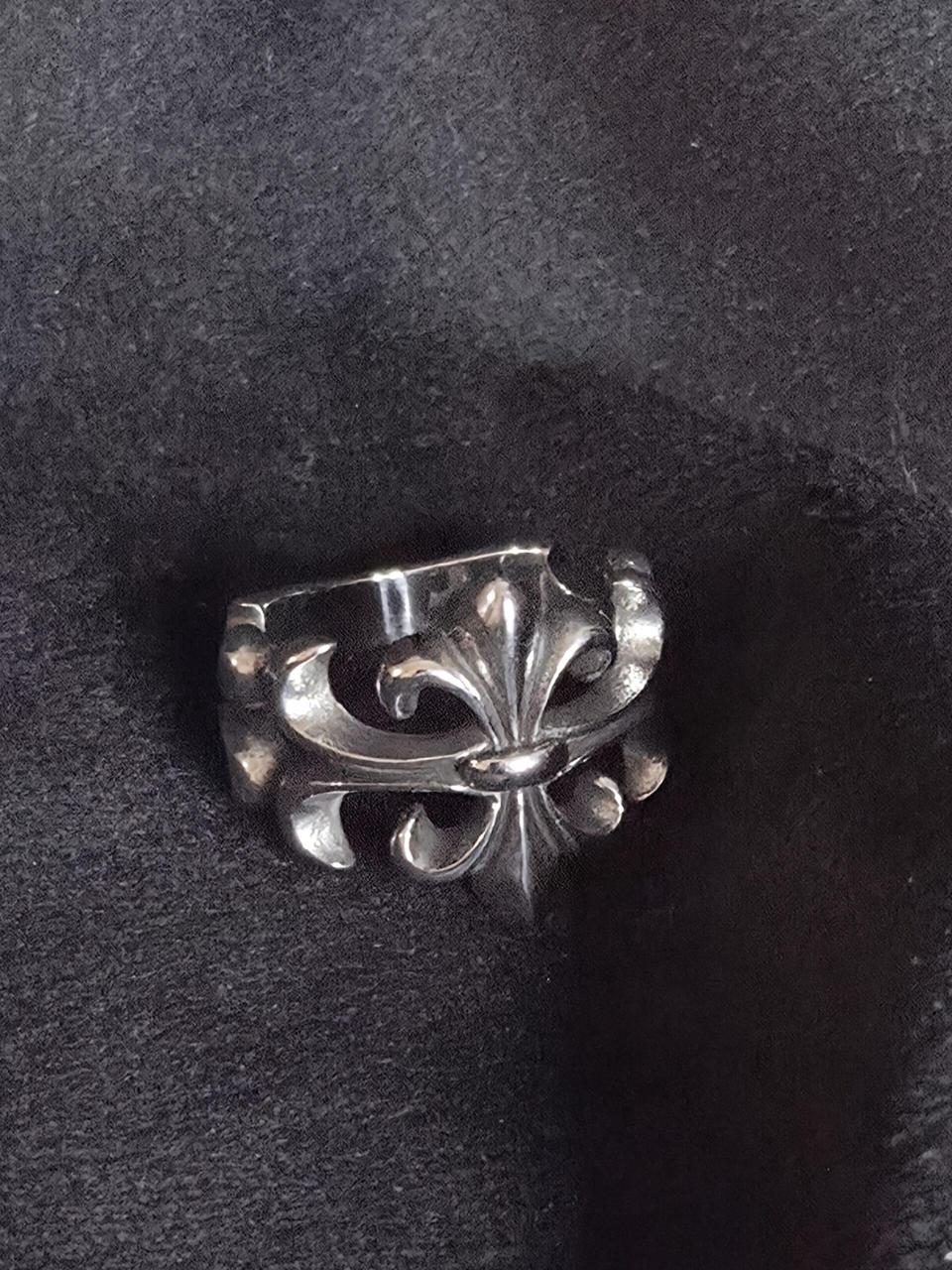 Gootti fleur-de-lis sormus, ruostumatonta terästä mustalla taustalla